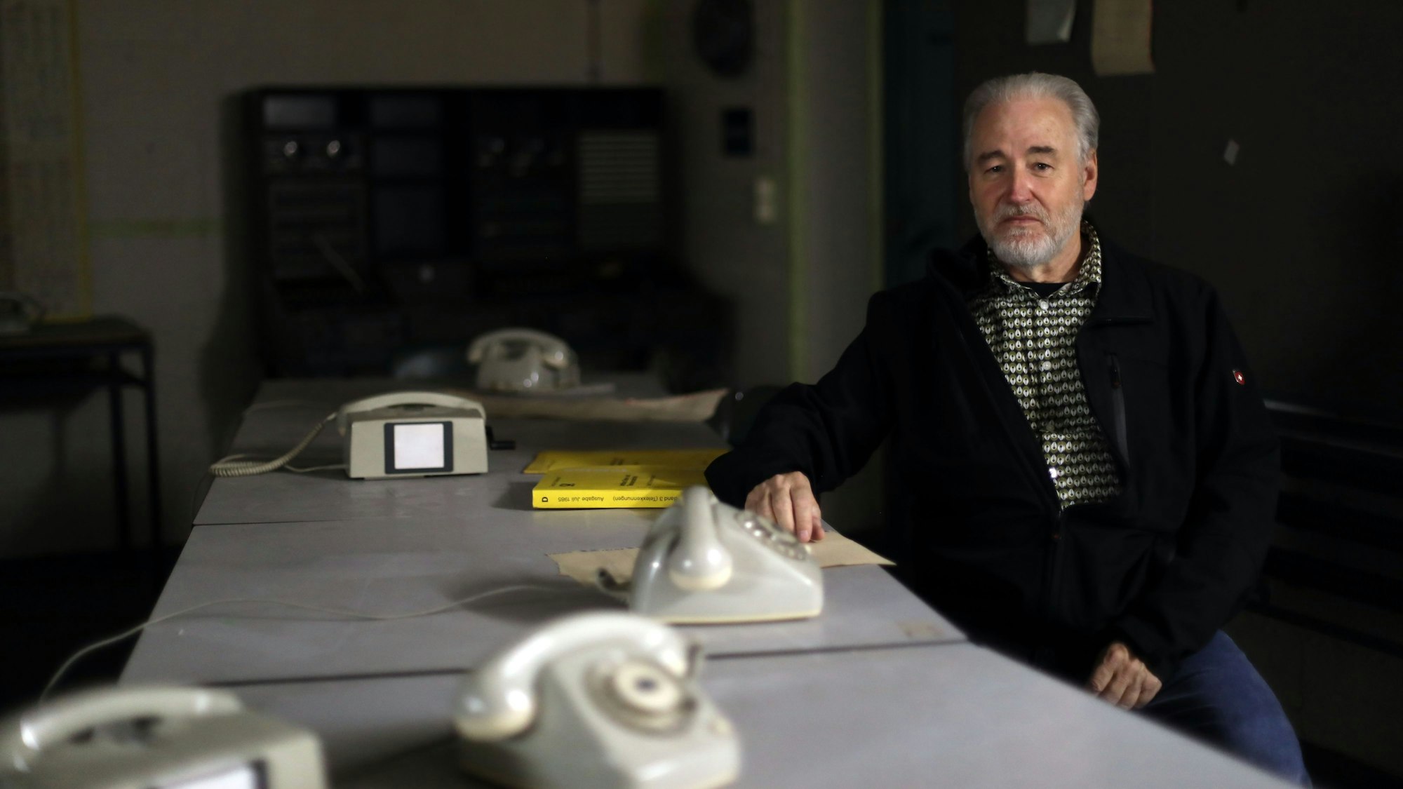 Robert Schwienbacher sitzt in der Kommandozentrale an einem Schreibtisch mit Telefonen.