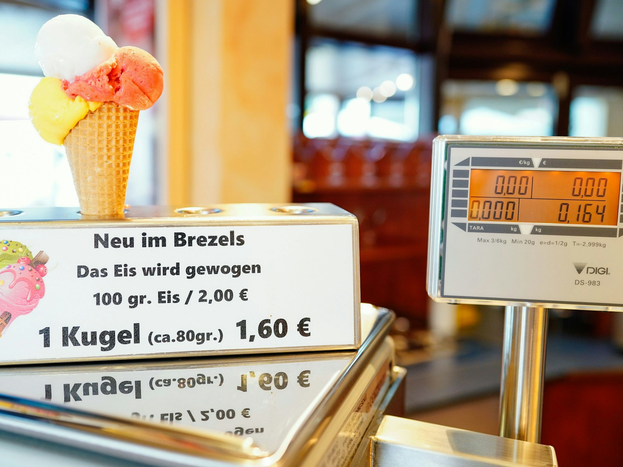 Baden-Württemberg, Gaggenau: Ein Eis in einer Waffel steht im Café ·Brezels· auf einer Waage.