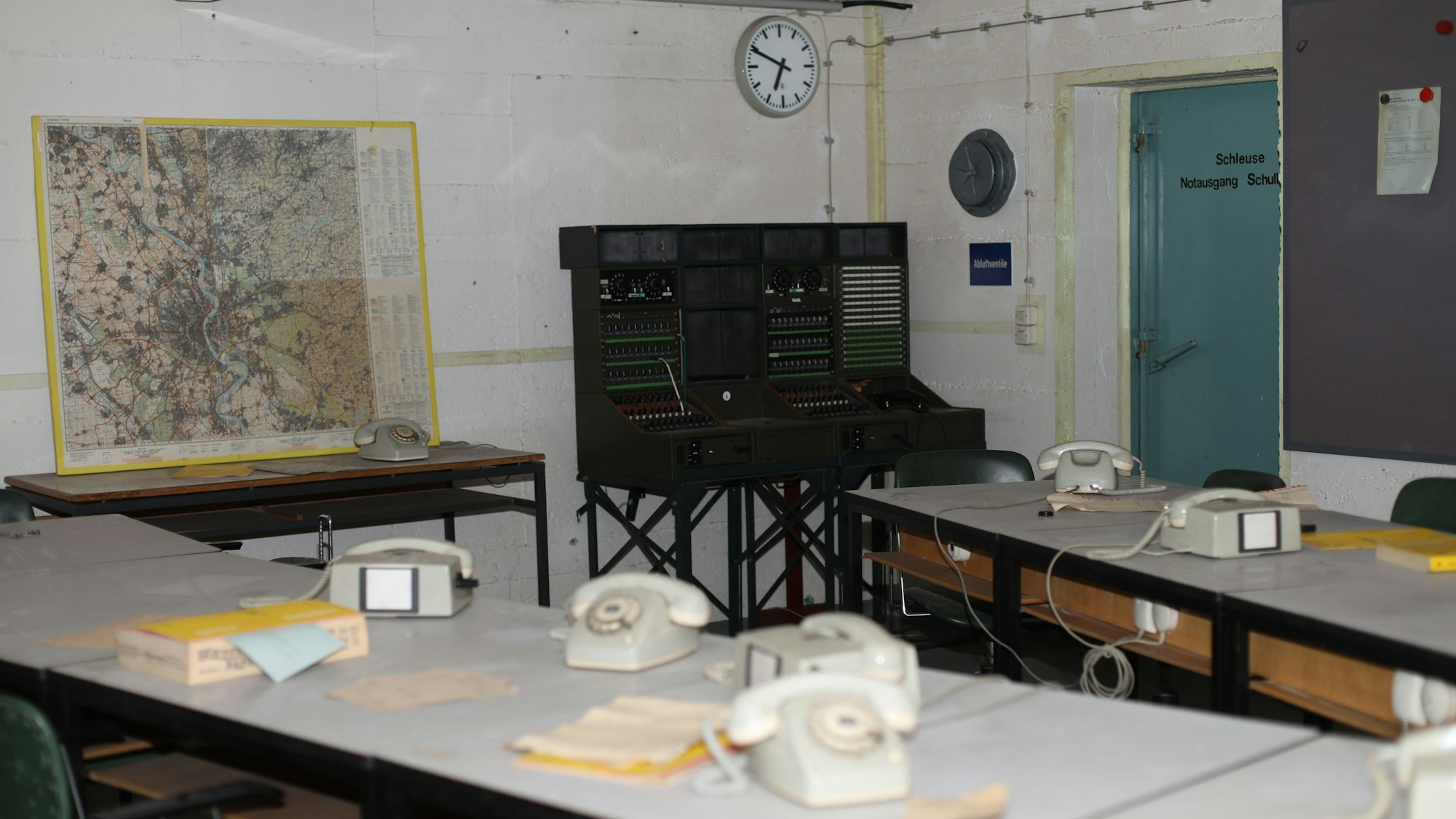 Raum in der Kommandozentrale mit Telefonen, Schreibtischen und einer großen Karte von Köln