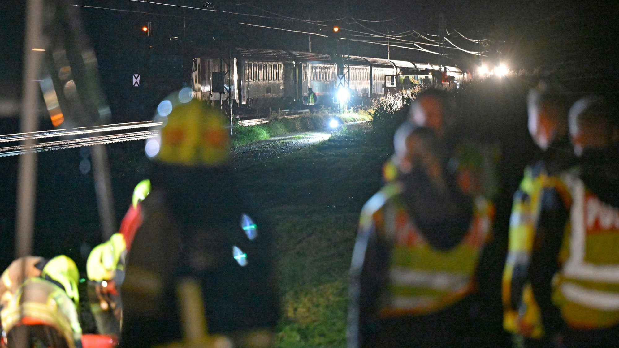 13.08.2024, Bayern, Bad Endorf: Feuerwehrleute stehen an einem Einsatzort zwischen Bad Endorf und Prien nahe dem Chiemsee, wo ein Eurocity mit einem in den Gleisbereich gestürzten Baum kollidiert und liegengeblieben ist. Nach Polizeiangaben mussten mehr als 200 Menschen aus dem Zug geholt werden. Foto: Uwe Lein/dpa +++ dpa-Bildfunk +++