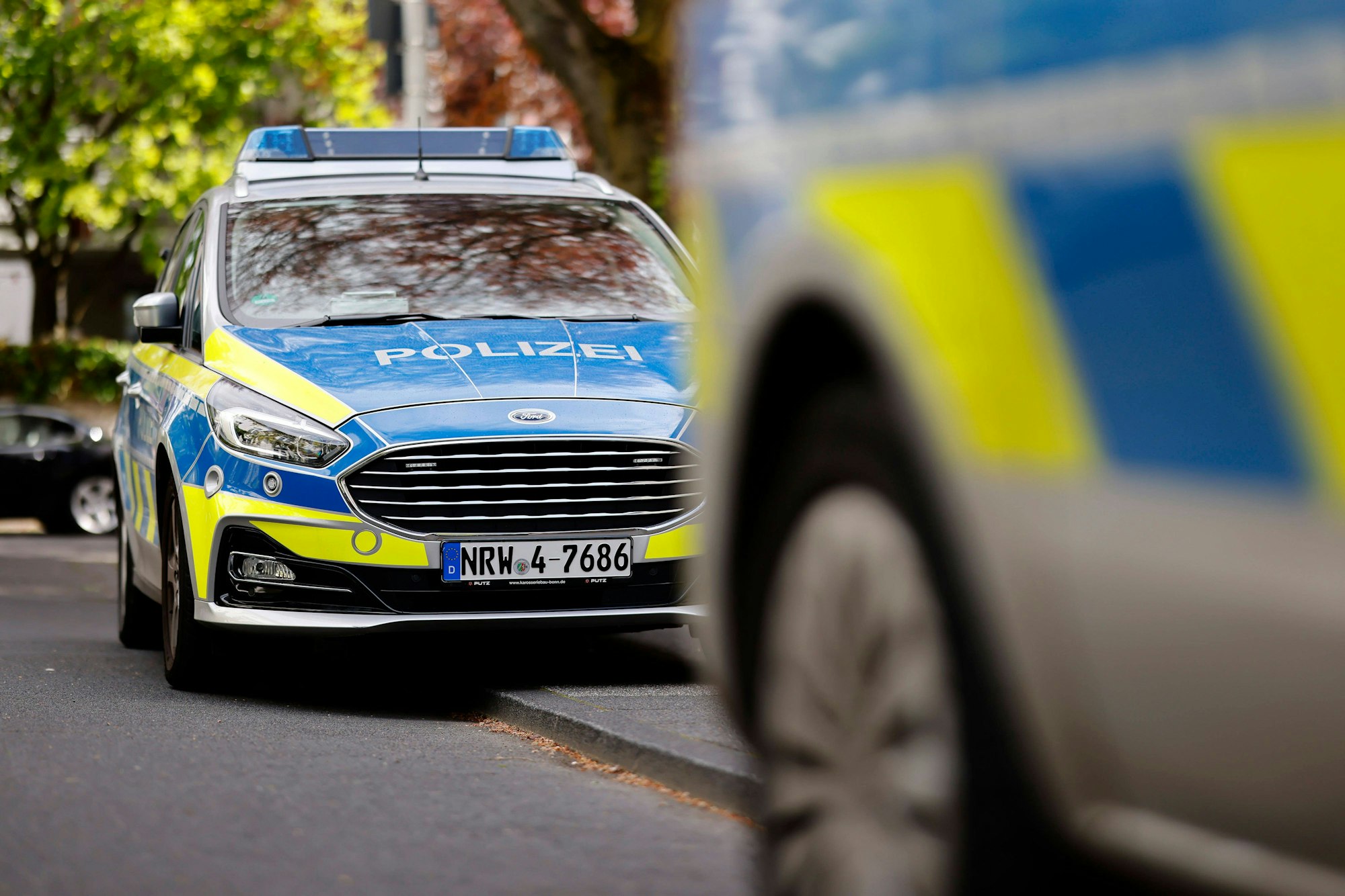 Polizeiautos begleiten eine Demo in Bonn.