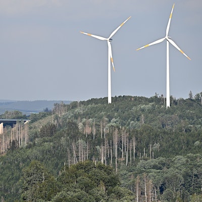 Zwei Windräder überragen in einem Waldgebiet bei Gummersbach-Piene deutlich die Wipfel der Bäume.