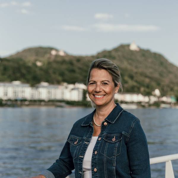 Eine Frau, im Hintergrund der Rhein und das Siebengebirge
