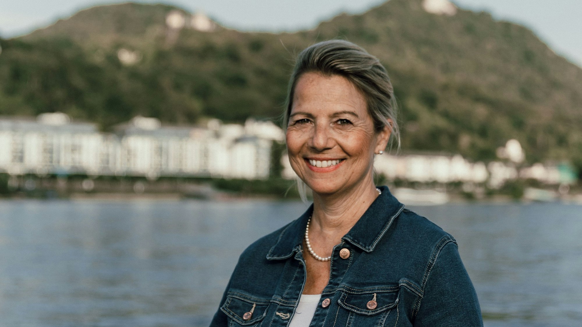 Eine Frau, im Hintergrund der Rhein und das Siebengebirge