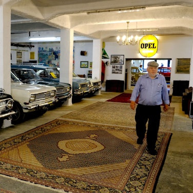 Josef Degener geht durch eine Halle seines privaten Opel-Museums in Vogelsang.