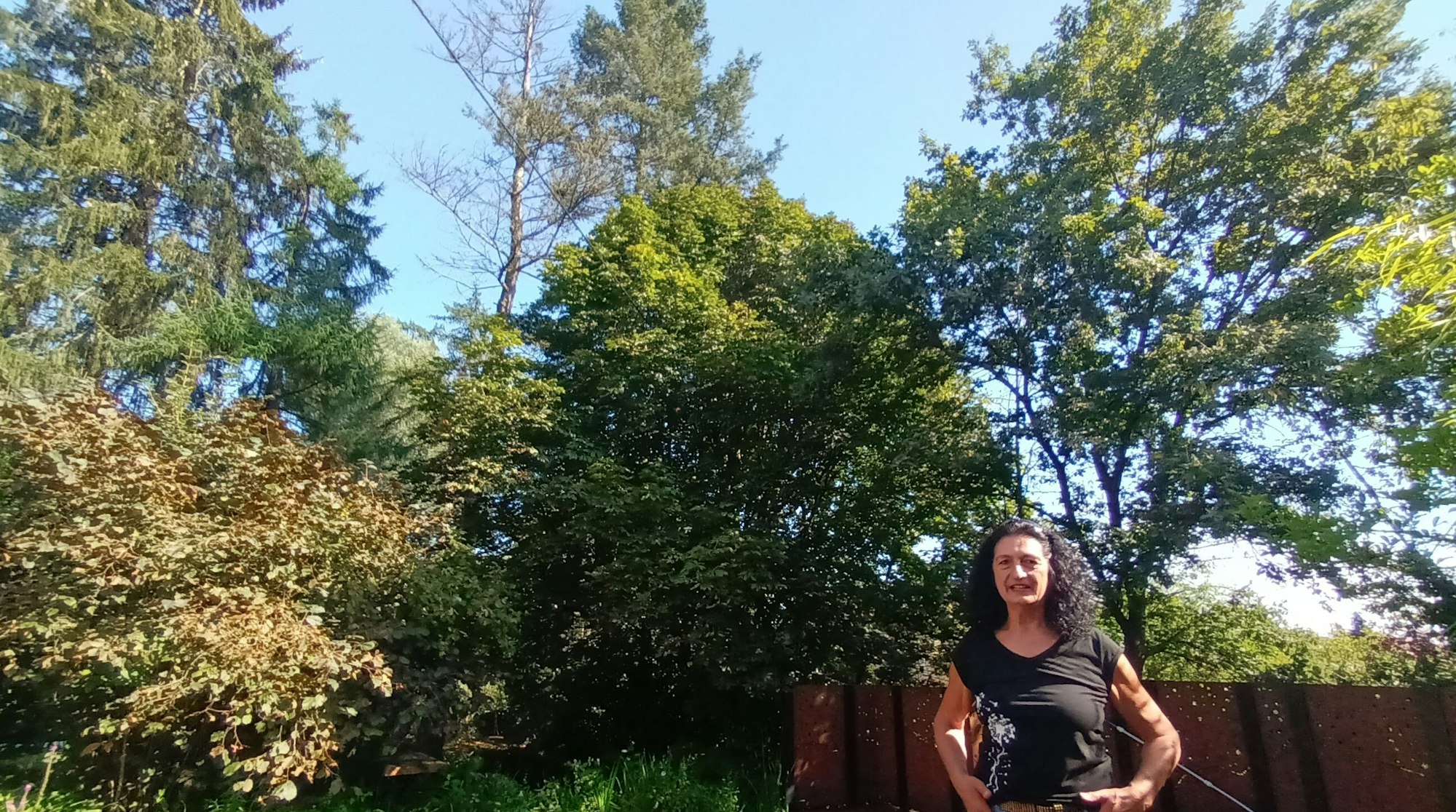 Eine Frau steht vor Bäumen