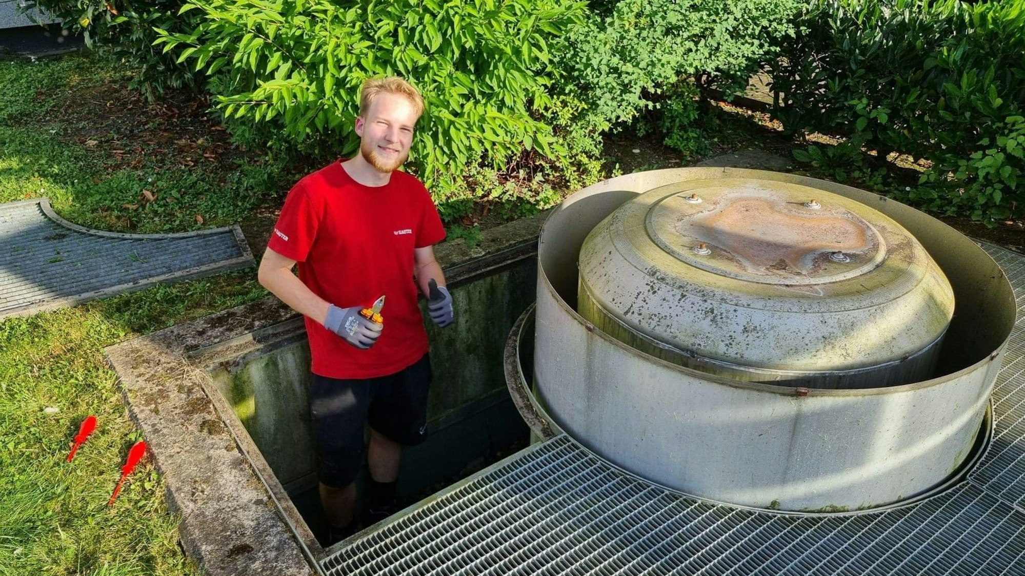 Ein Mann mit rotem T-Shirt steht neben dem Belüftungssystem, aus dem eine Elster befreit wurde.