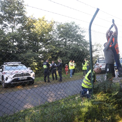 Mitarbeiter des Flughafens reparieren den beschädigten Zaun am Flughafen Köln-Bonn.