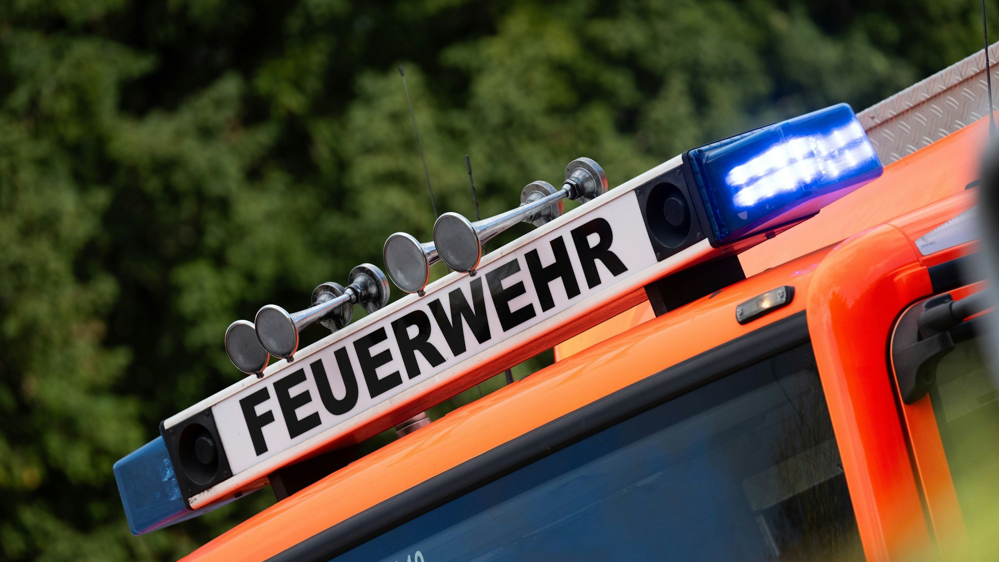 Blaulicht ist während eines Brandes auf einem Einsatzfahrzeug der Feuerwehr zu sehen.