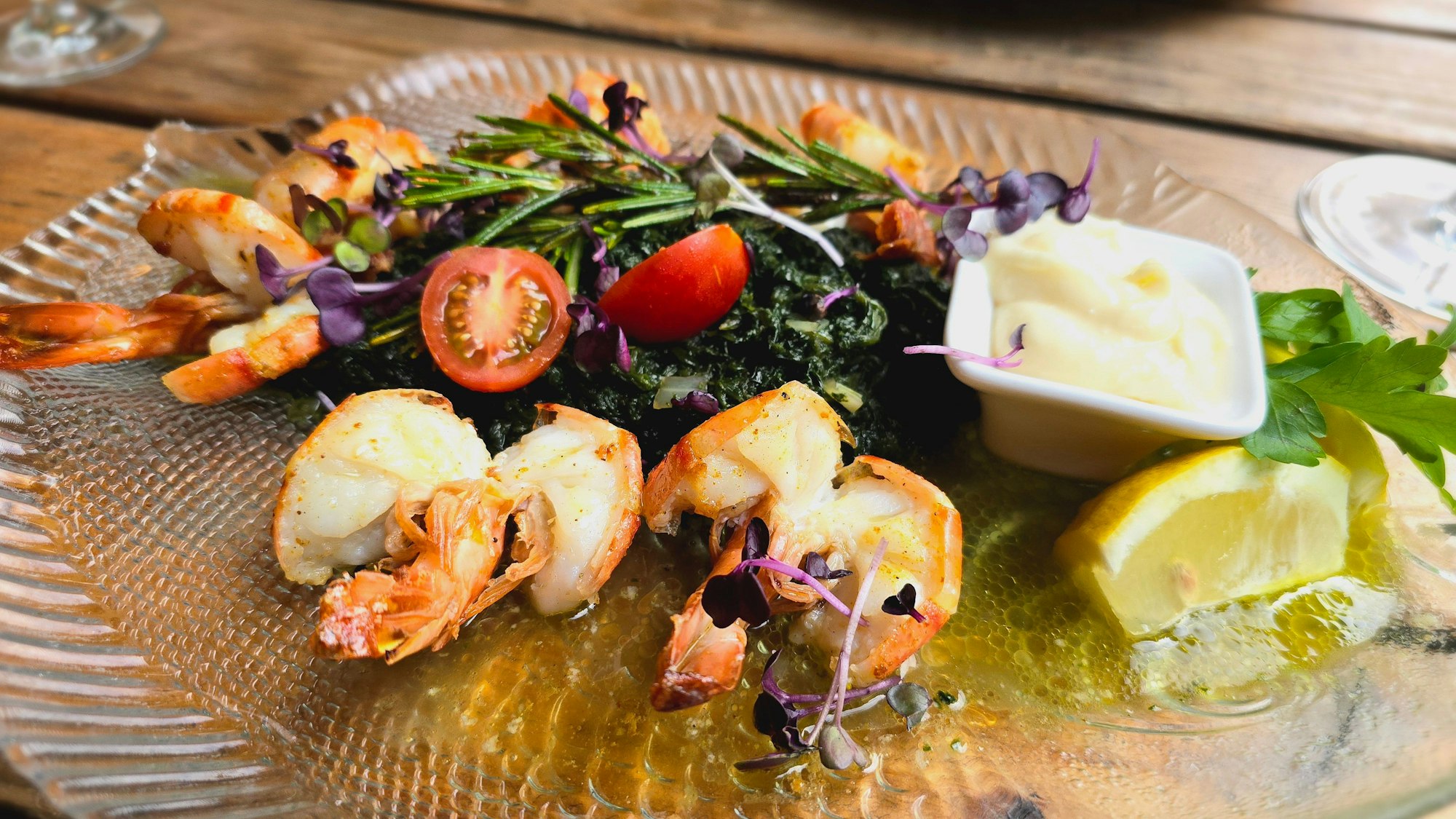 Ein Tellergericht mit Garnelen, Dip und Rosmarin über alles gelegt.