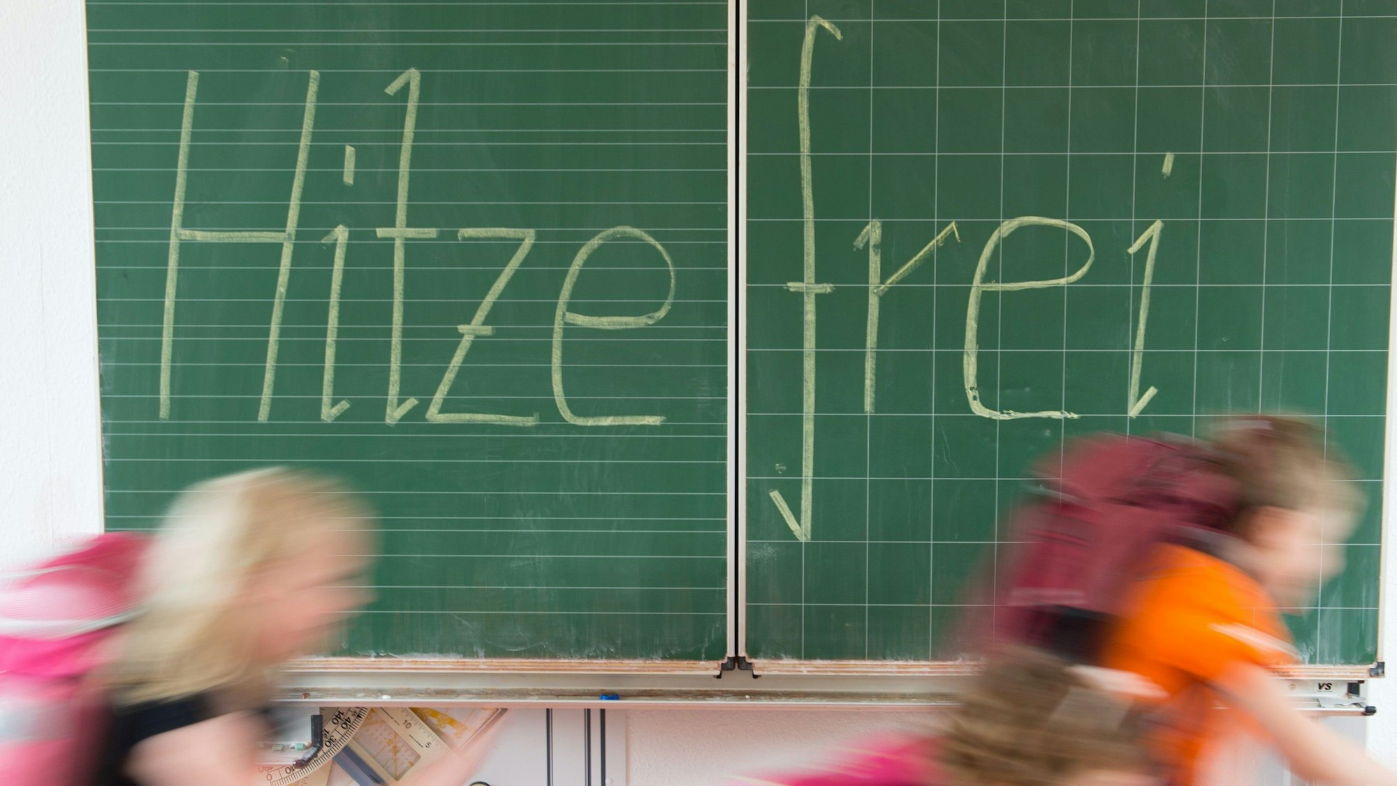 Kinder vor einer Tafel.