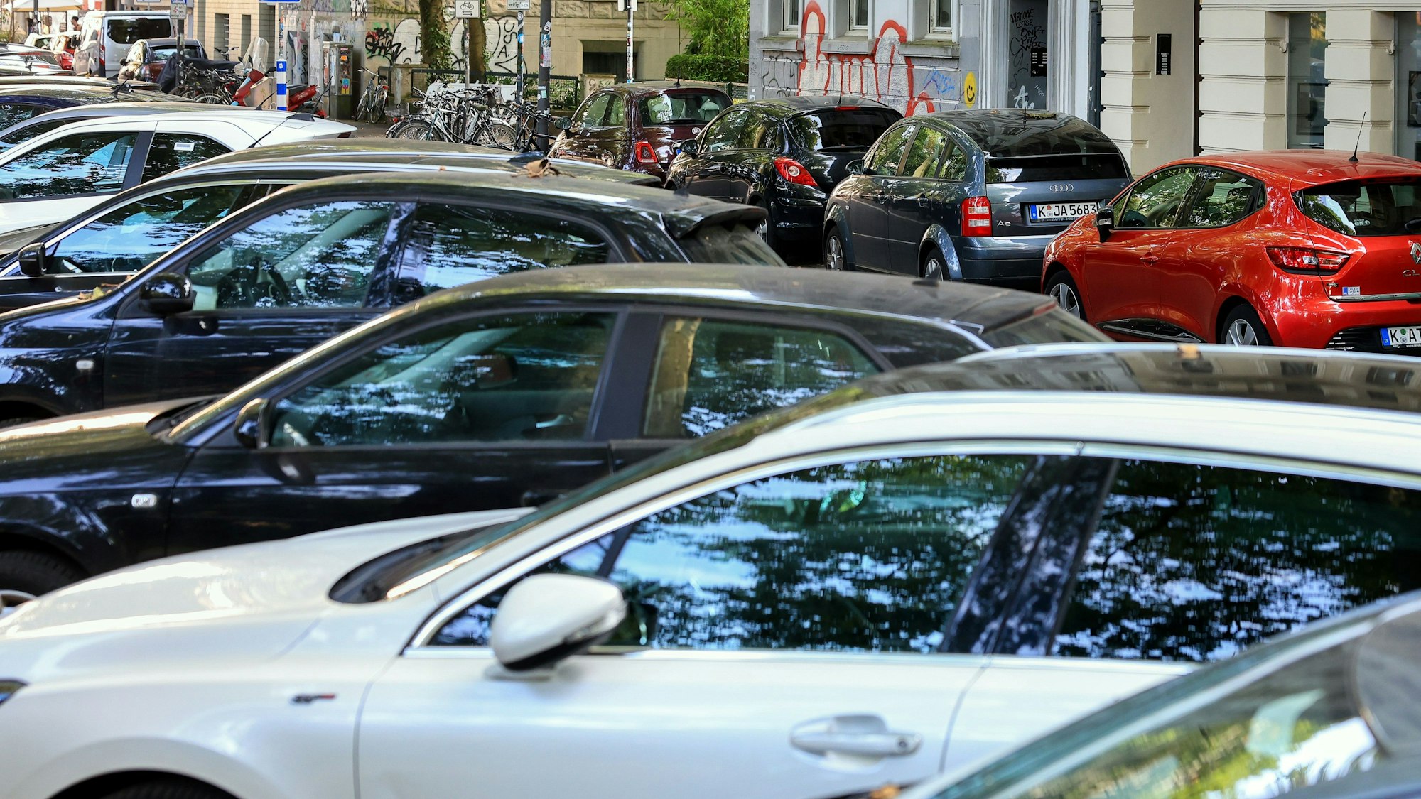 Parkende Autos bestimmen das Straßenbild am Kölner Rathenauplatz: Beide Straßenseiten sind durch neben- und hintereinander stehende Autos verdeckt.