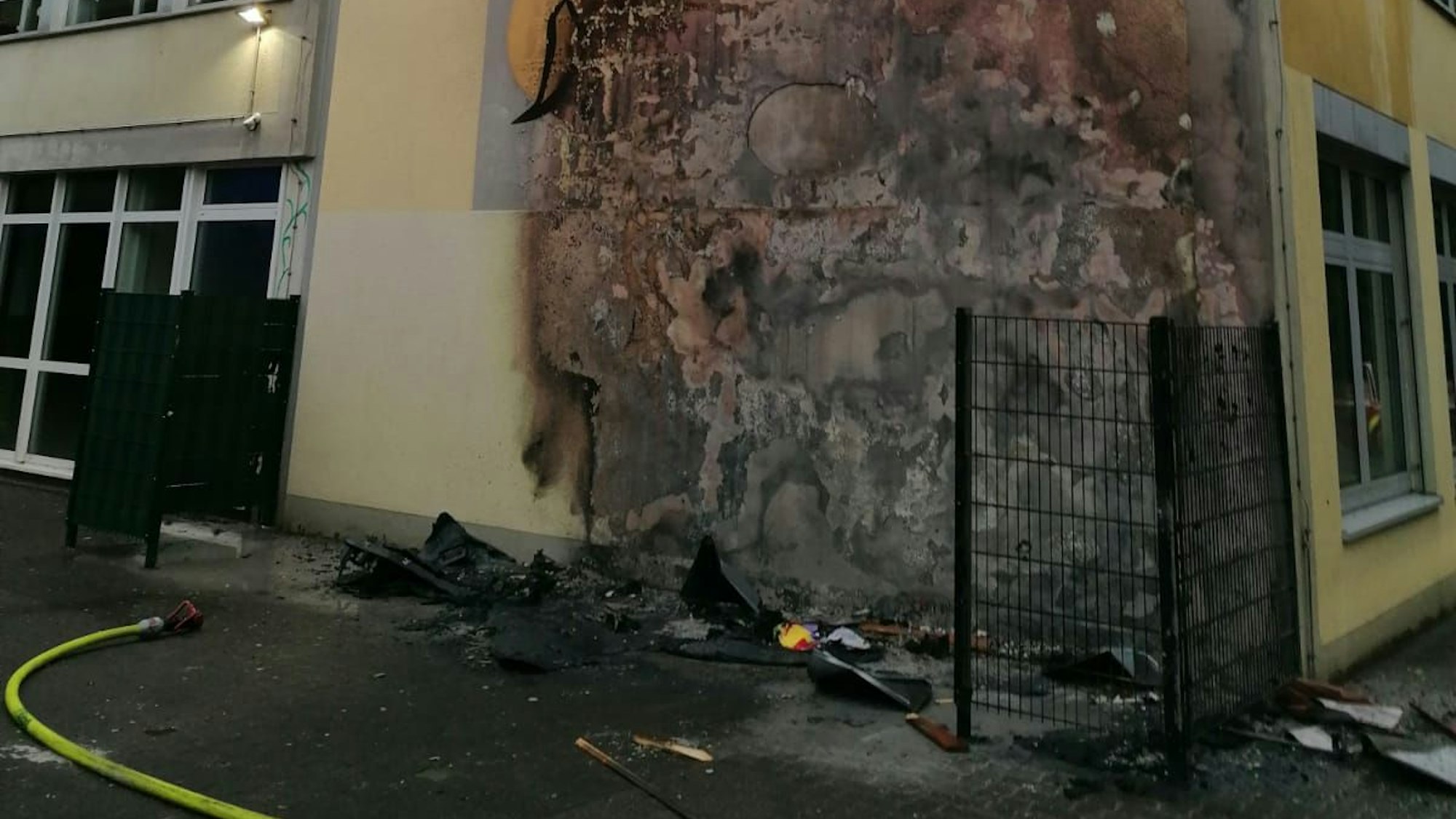 Eine Hauswand der Katholischen Grundschule am Sandweg in Rösrath ist durch einen Brand schwer beschädigt.