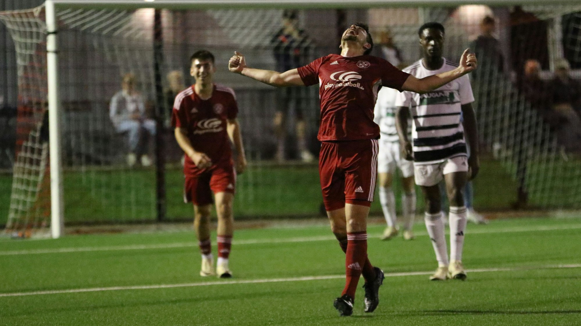 Zülpichs Torschütze breitet die Arme aus und blickt in den Himmel. Ein Mitspieler im Hintergrund freut sich, ein Gegenspieler weniger.