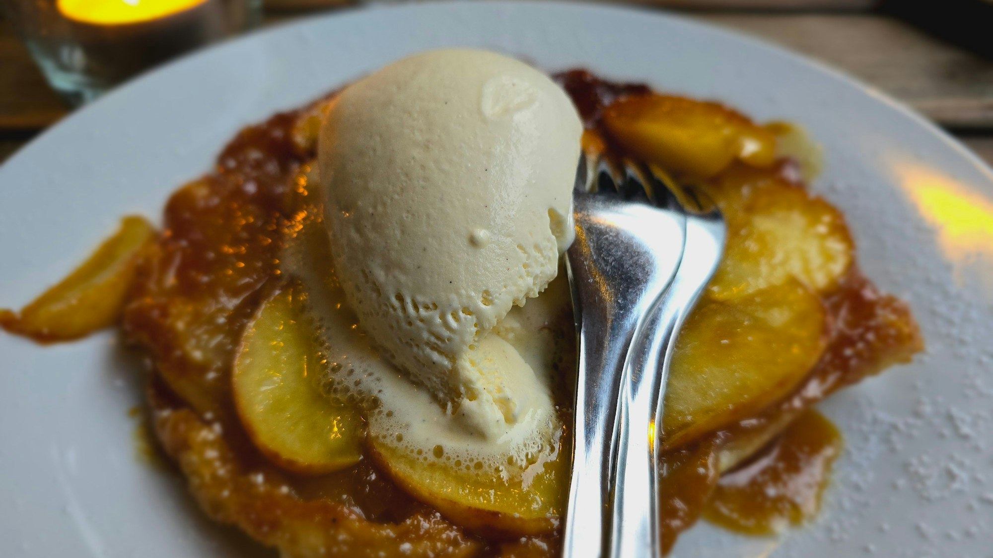 Die Apfeltarte ist mit Eis auf einem Teller zu sehen.