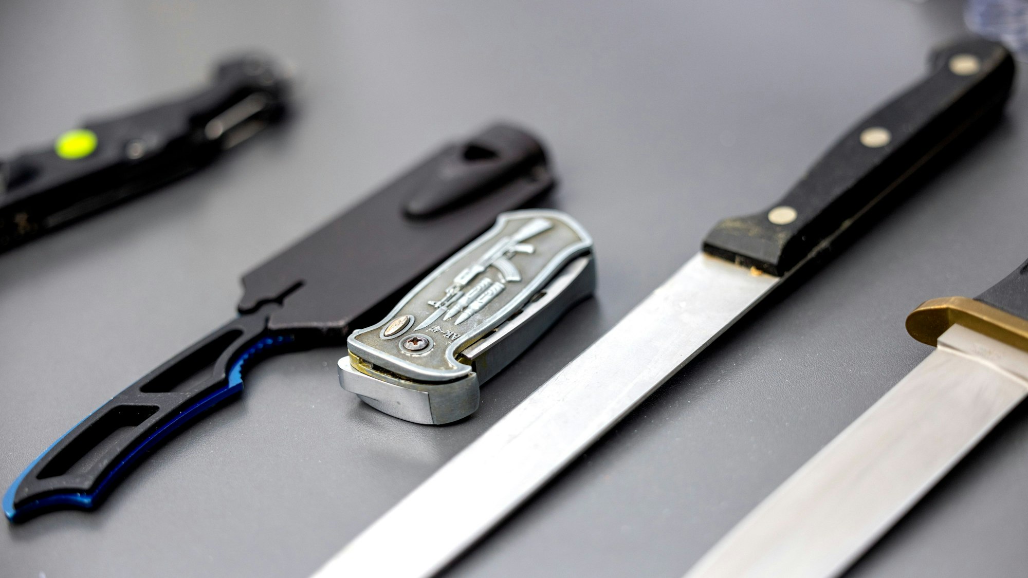 Auf einem Tisch liegen von der Polizei sichergestellte verbotene Stichwaffen.