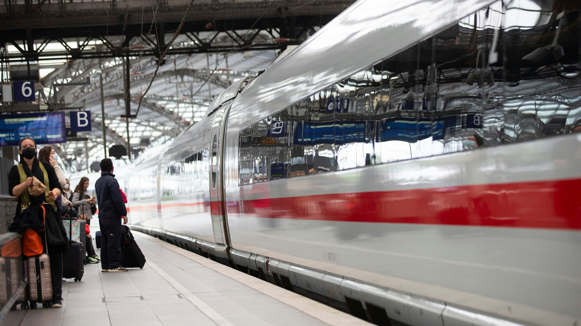 Reisende stehen an einem Bahngleis am Hauptbahnhof Köln