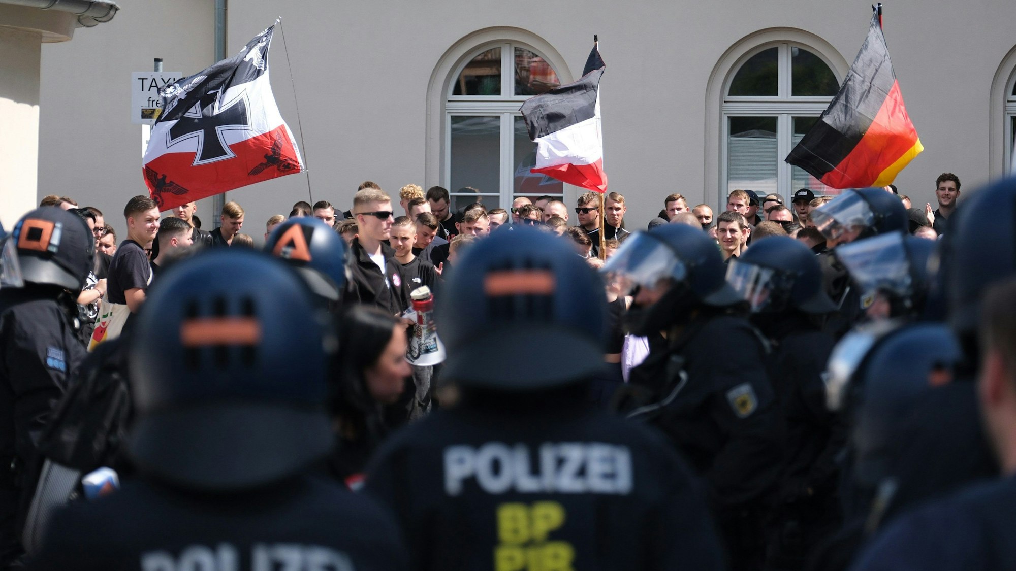 Teilnehmer einer rechten Demonstration in Bautzen werden am Bahnhof von Polizisten begleitet.