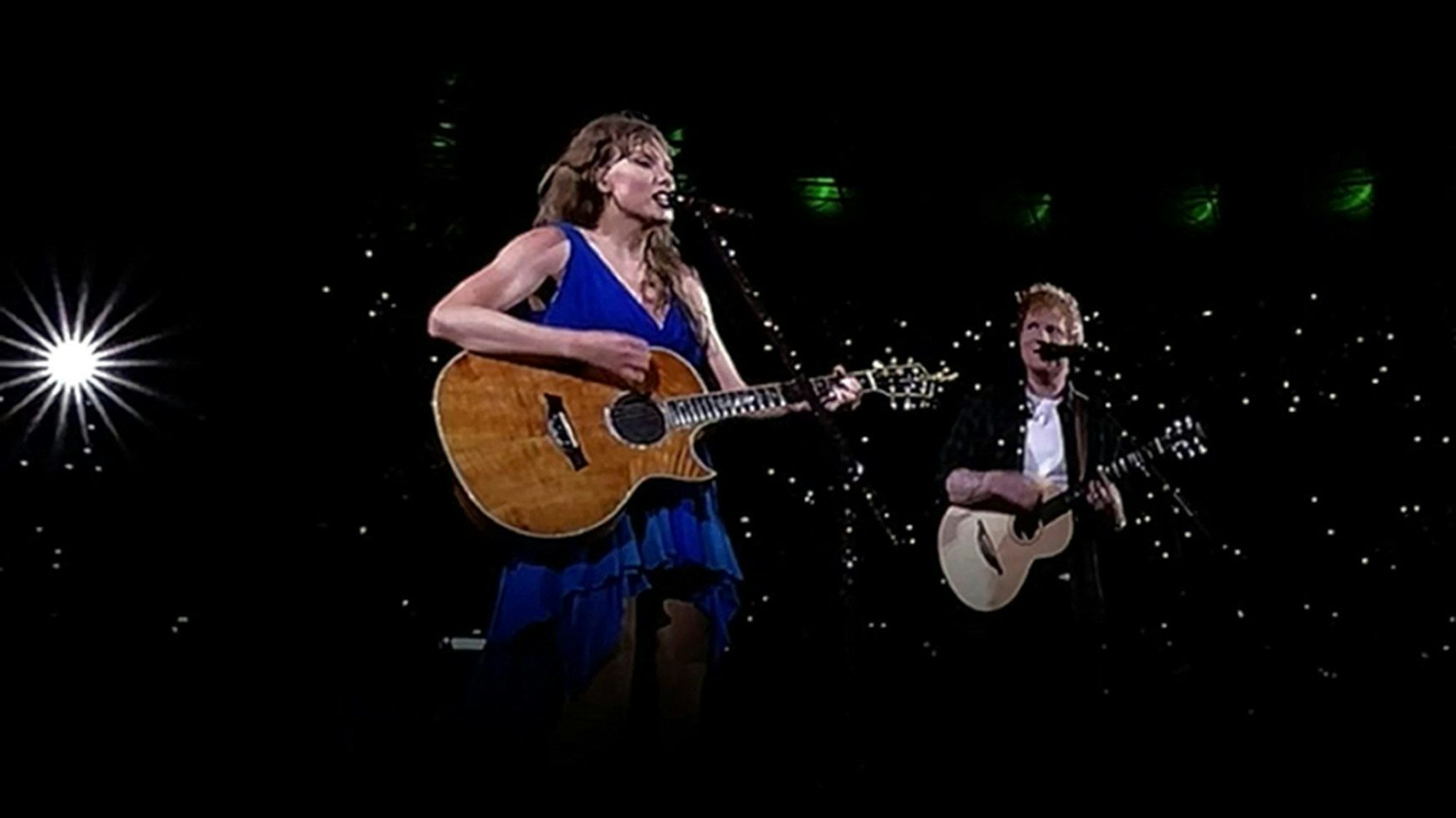 Das von einem großen Bildschirm abfotografierte Videobild zeigt die US-Sängerin Taylor Swift, die mit ihrem Überraschungsgast Ed Sheeran während ihres Konzerts der Eras Tour im Wembley Stadion auftritt.