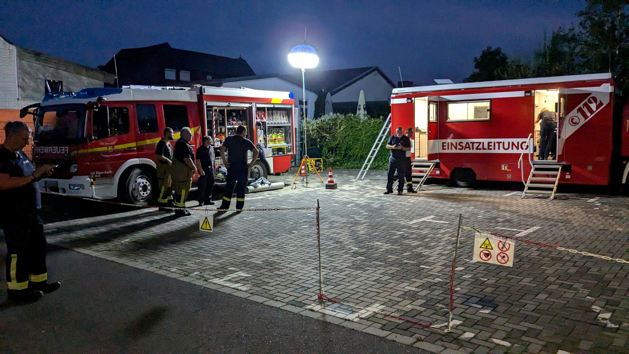 Zwei Einsatzfahrzeuge der Feuerwehr stehen in der Dunkelheit auf einem Parkplatz in Mechernich. Ein Powermoon beleuchtet die Szenerie.