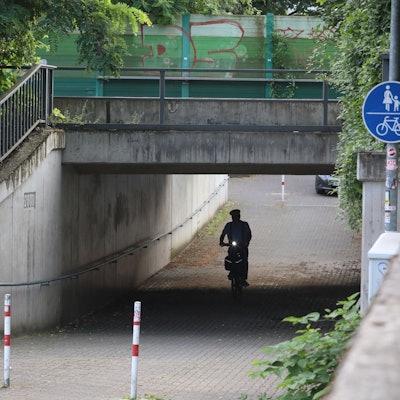 Ein Radfahrer führt durch eine Unterführung.