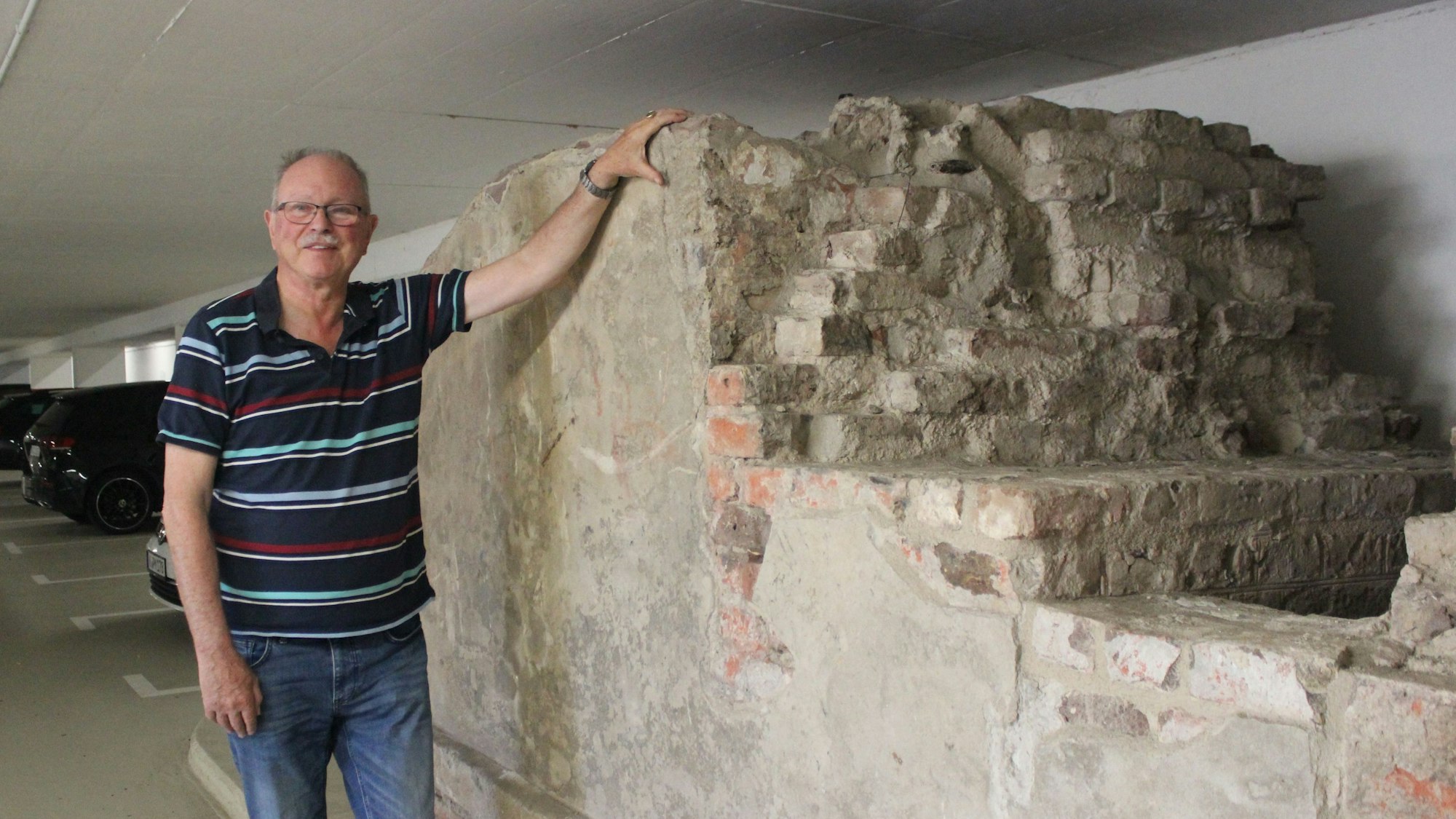 Wolfgang Uellenberg van Dawen am Mauerrest des Forts III in der Tiefgarage seines Wohnblocks