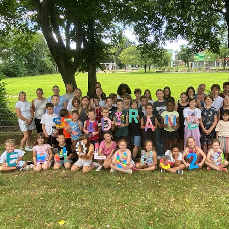 Kinder halten die Buchstaben "Stadtranderholung" hoch.