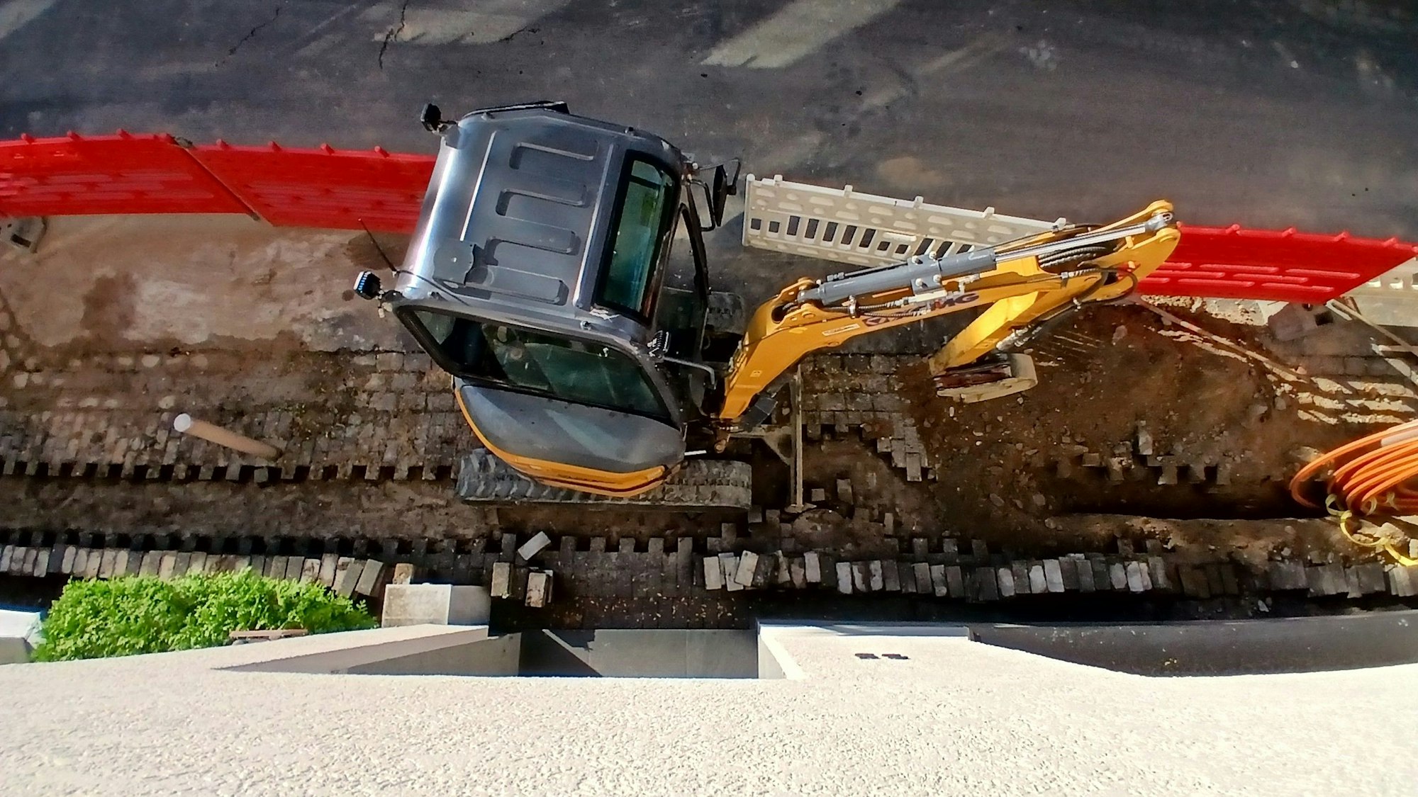 Ein Minibagger in einer abgesperrten Glasfaserbaustelle