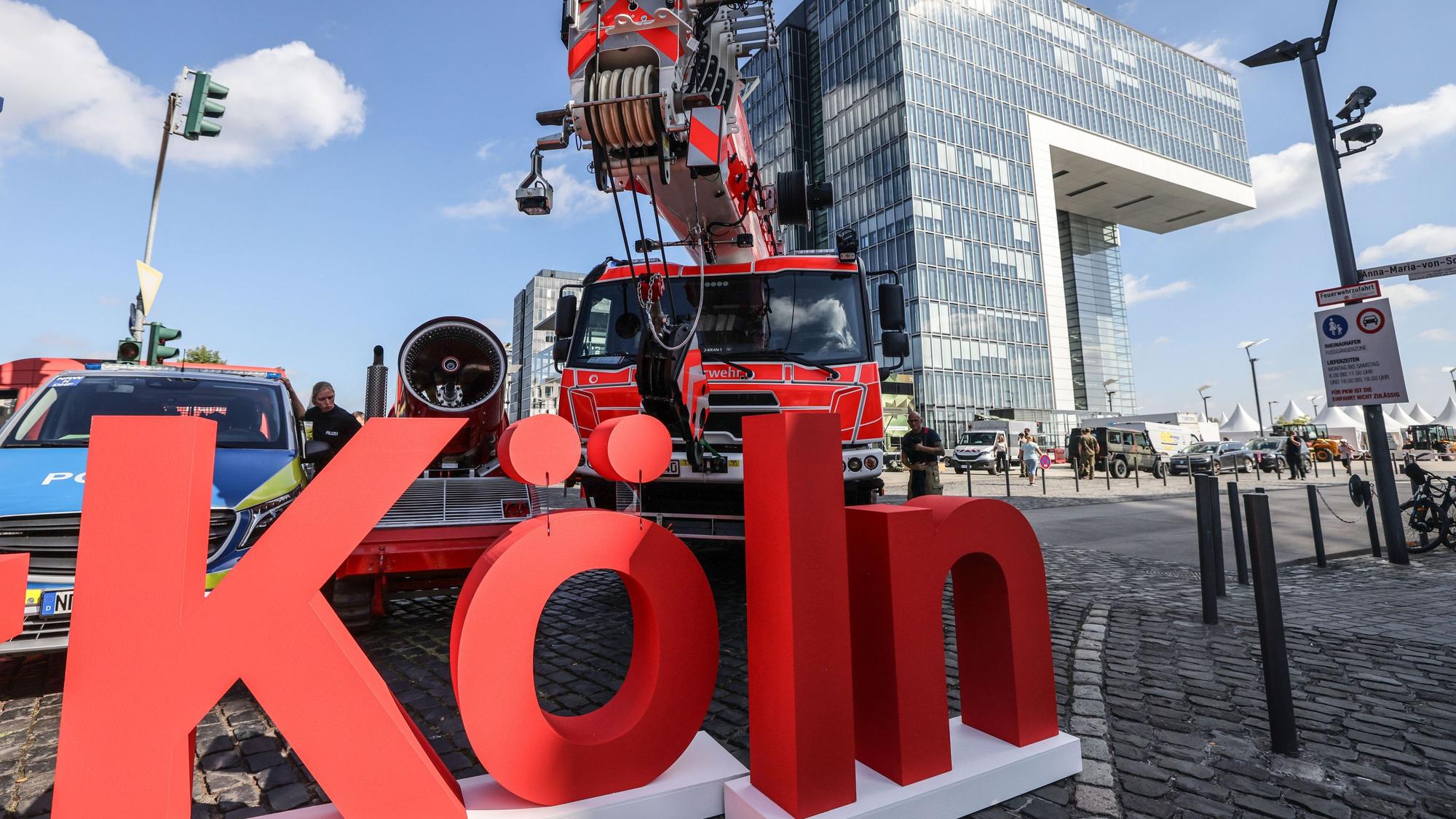Der Schriftzug der Stadt Köln steht im Rheinauhafen vor Behördenfahrzeugen.