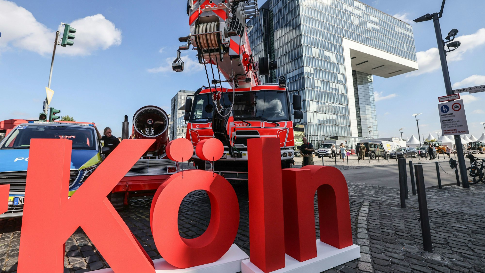 Der Schriftzug der Stadt Köln steht im Rheinauhafen vor Behördenfahrzeugen.