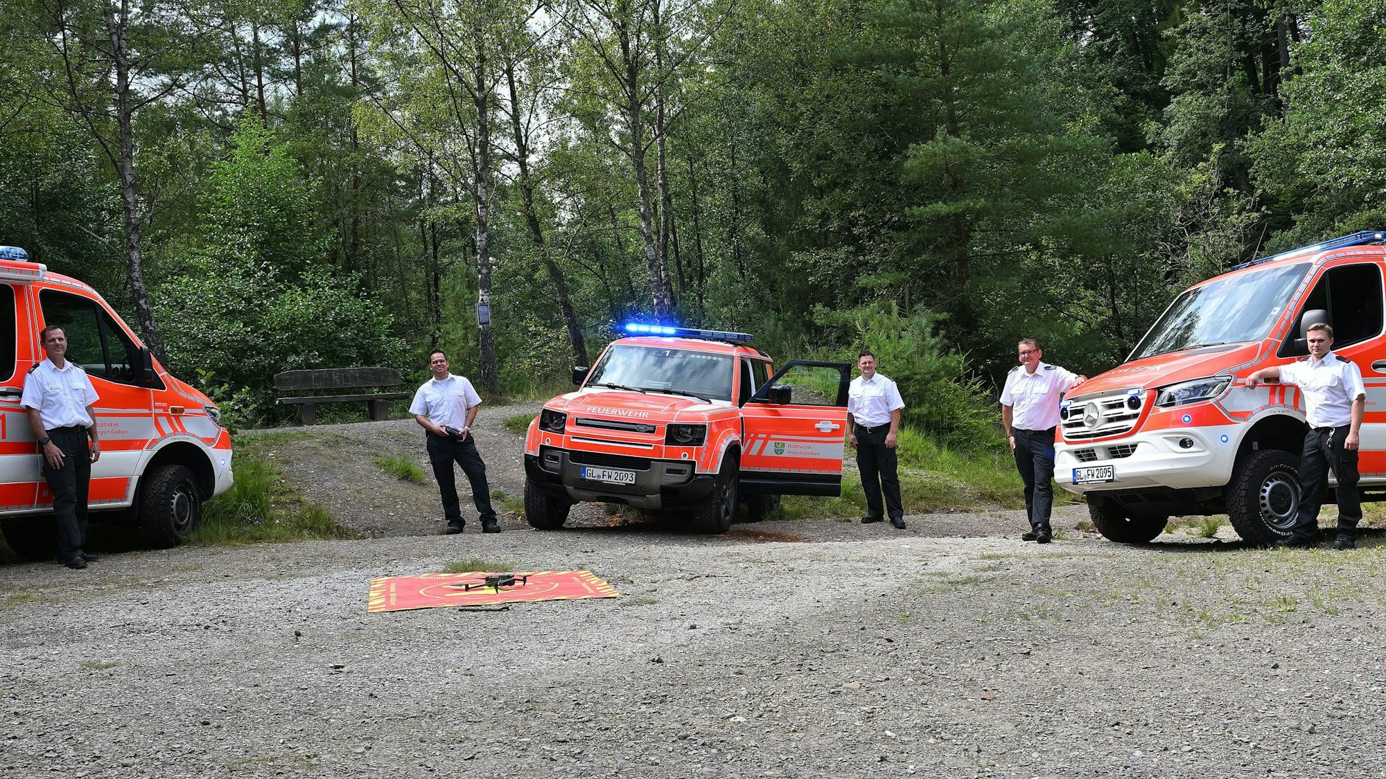 Drei neue Fahrzeugen der Feuerwehr Bergisch Gladbach stehen auf einem Schottergelände in der Hardt.