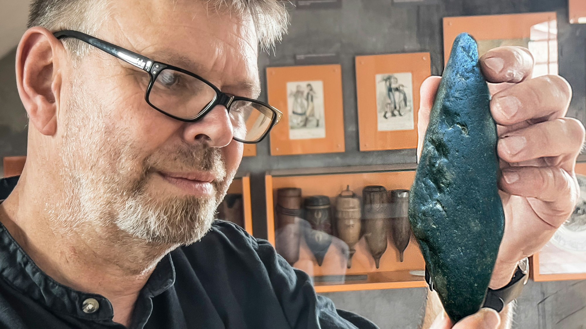 Den offenbar historischen Sensenwetzstein vom Wupperufer betrachtet Jürgen Bandsom, Leiter des Sensen- und UIndustreimuseums Freudenthaler