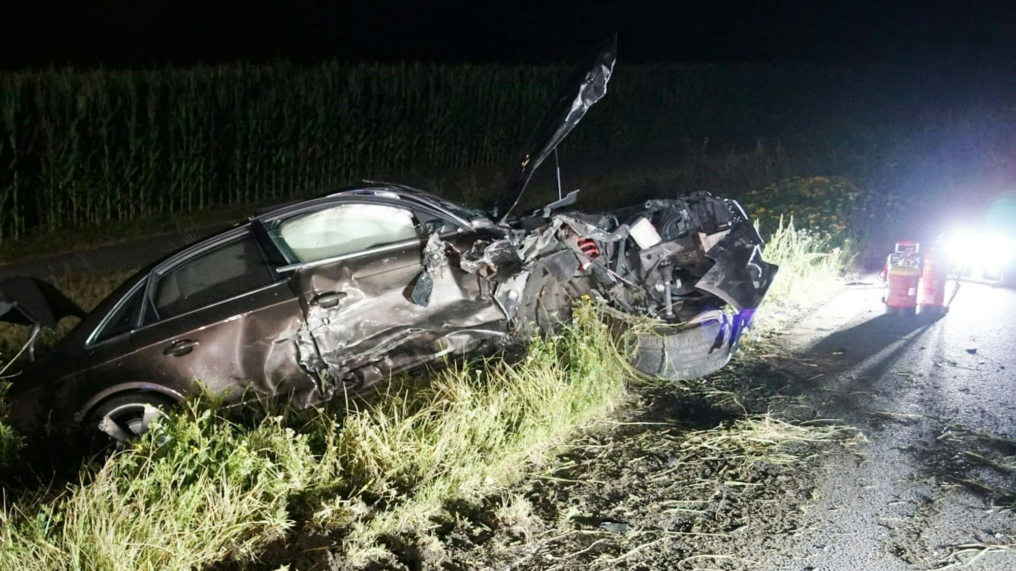 Ein stark beschädigtes Auto hängt im Straßengraben,