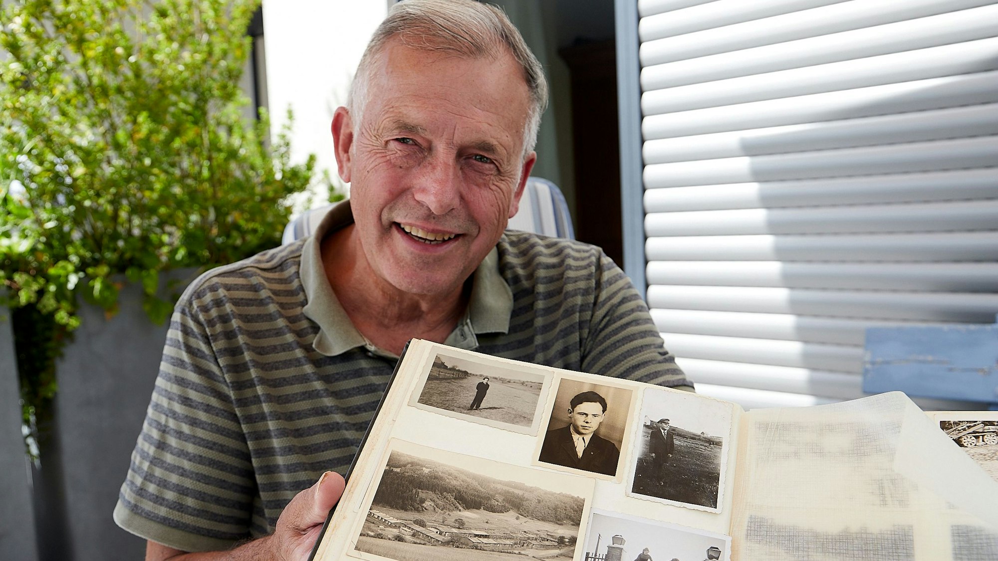Marzellus Boos zeigt Fotos in einem alten Familienalbum.