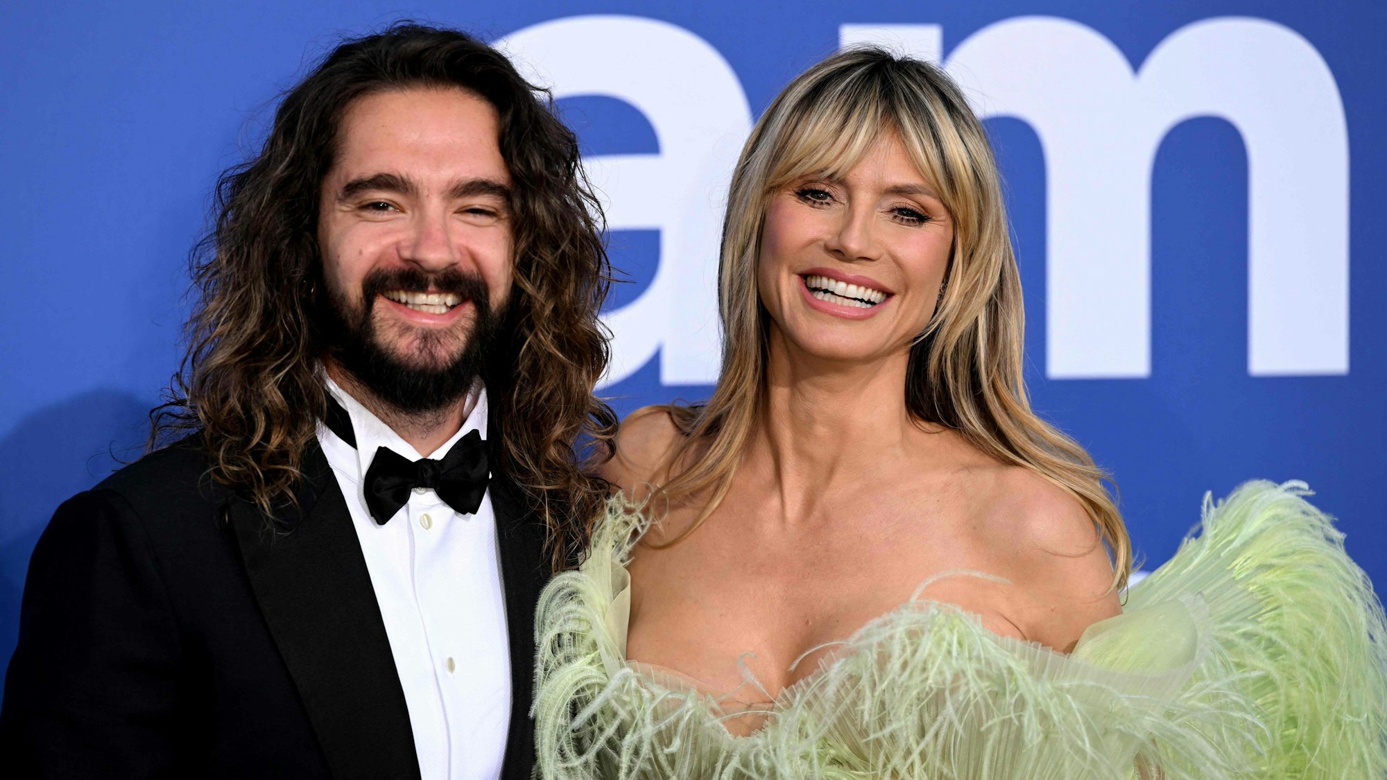 Tokio Hotel-Star Tom Kaulitz neben seiner Frau, Model Heidi Klum. Beide lächeln.