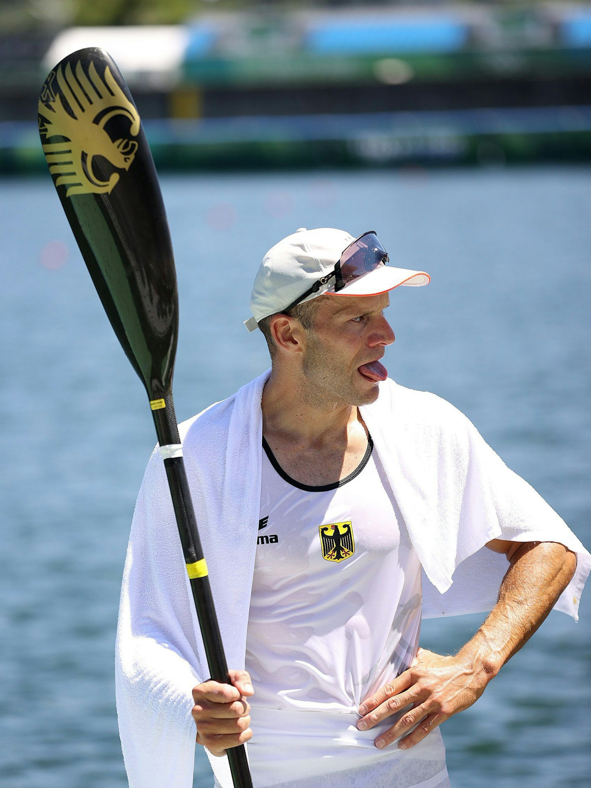 Max Hoff steht erschöpft am Wasser, mit dem Kanupaddel in der Hand.