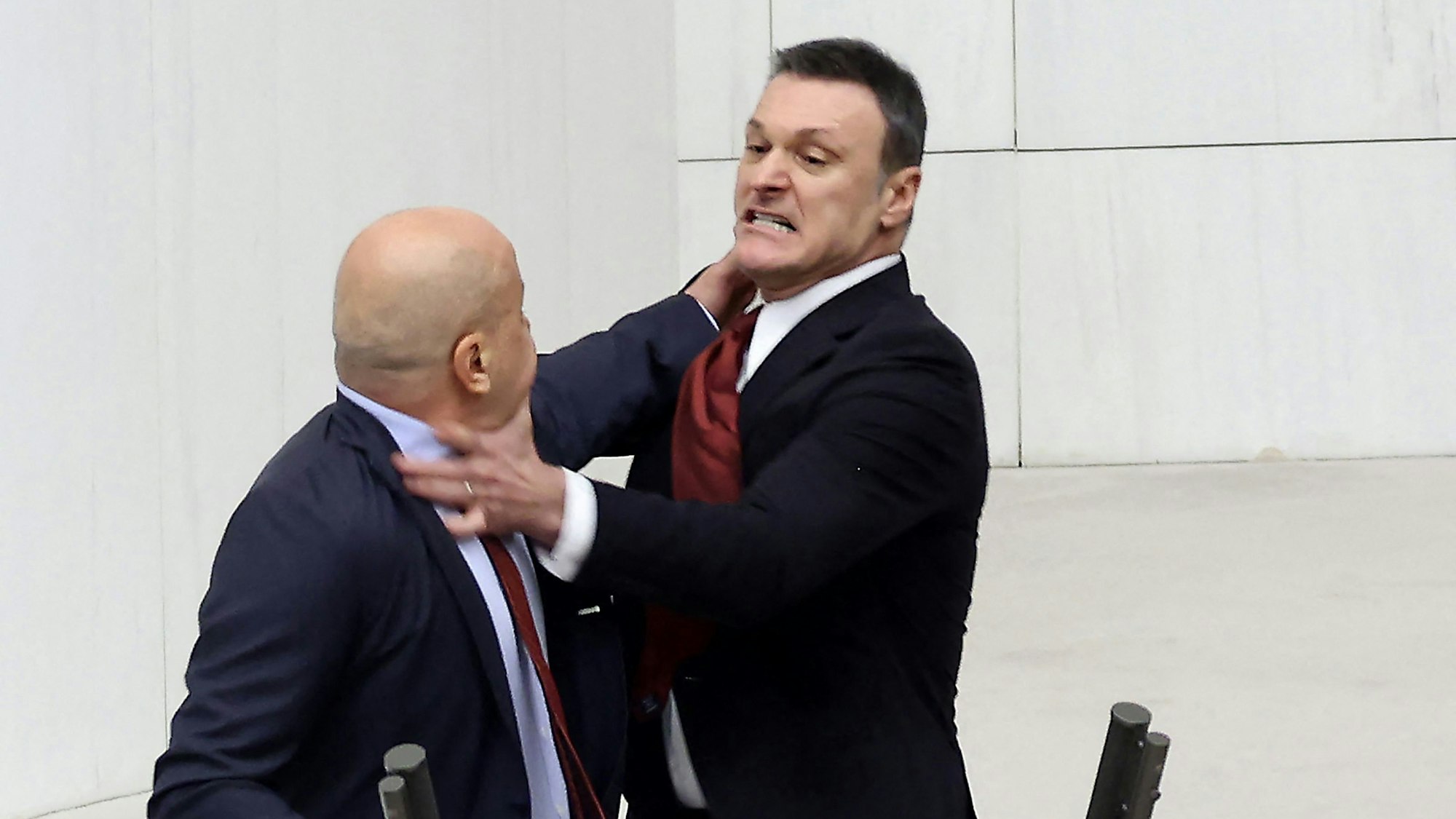 TOPSHOT - Former Turkish football player and deputy of ruling AKP (Justice and Development Party) Alpay Ozalan (R) scuffles with Turksih Workers Party (TIP) deputy Ahmet Sik (L) at Grand National Assembly of Turkey in Ankara on August 16, 2024. A brawl broke out in Turkey's parliament on August 16, 2024, after lawmakers convened to discuss the status of a jailed opposition figure controversially stripped of his parliamentary immunity earlier this year. They were meeting after the country's constitutional court earlier this month struck down parliament's decision to oust Can Atalay from his parliamentary seat. (Photo by Adem ALTAN / AFP)