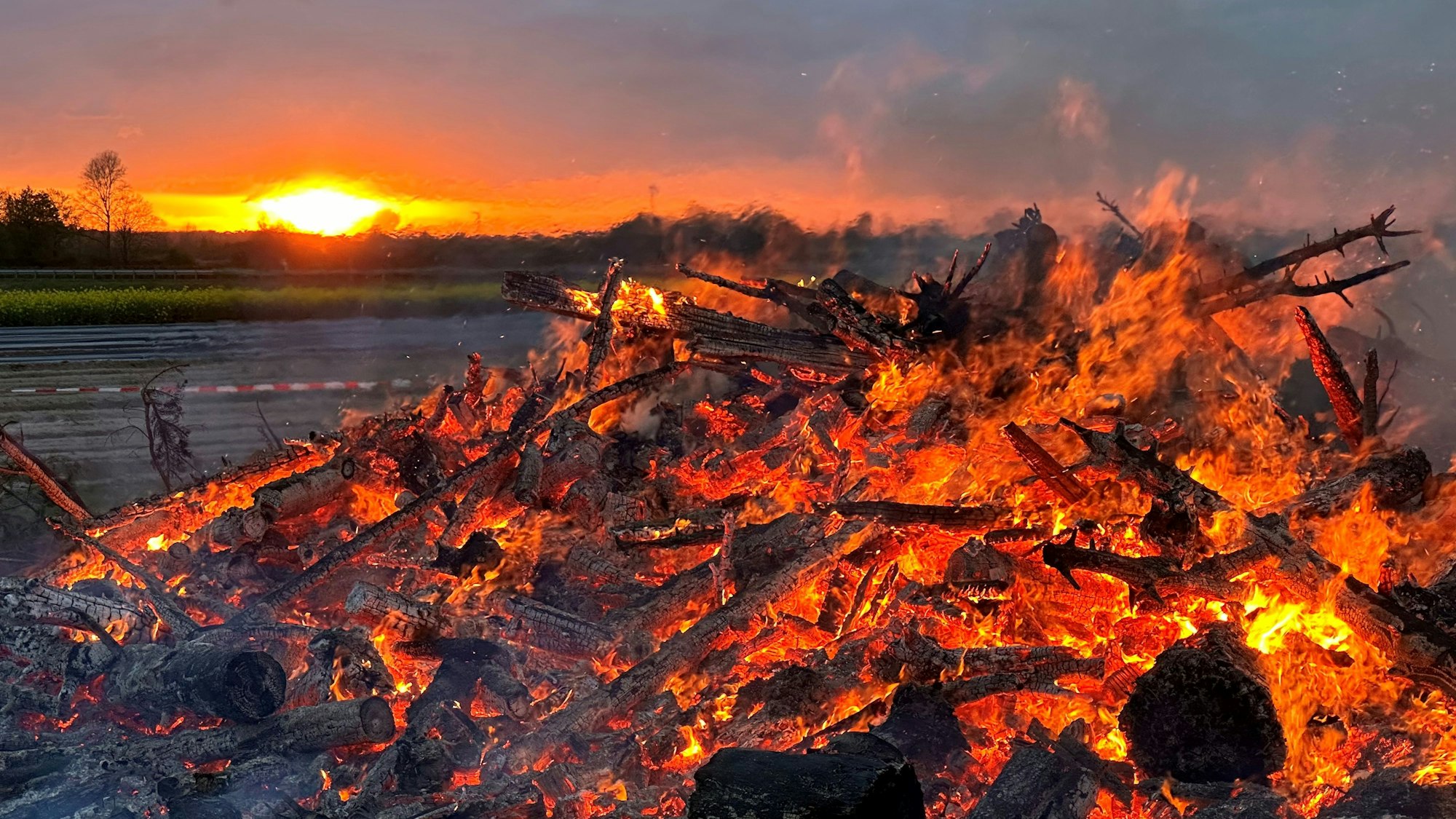 Ein glimmendes Lagerfeuer vor Sonnenuntergang – mehr Romantik ist kaum denkbar.