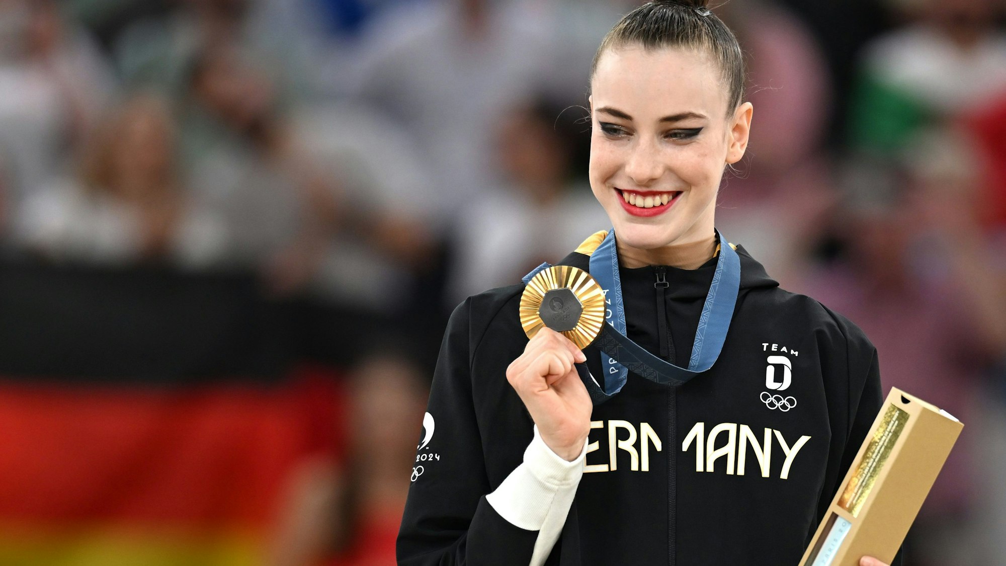 Darja Varfolomeev aus Deutschland zeigt in der Siegerehrung ihre Goldmedaille in der Rhythmischen Sportgymnastik bei den Olympischen Sommerspielen in Paris.