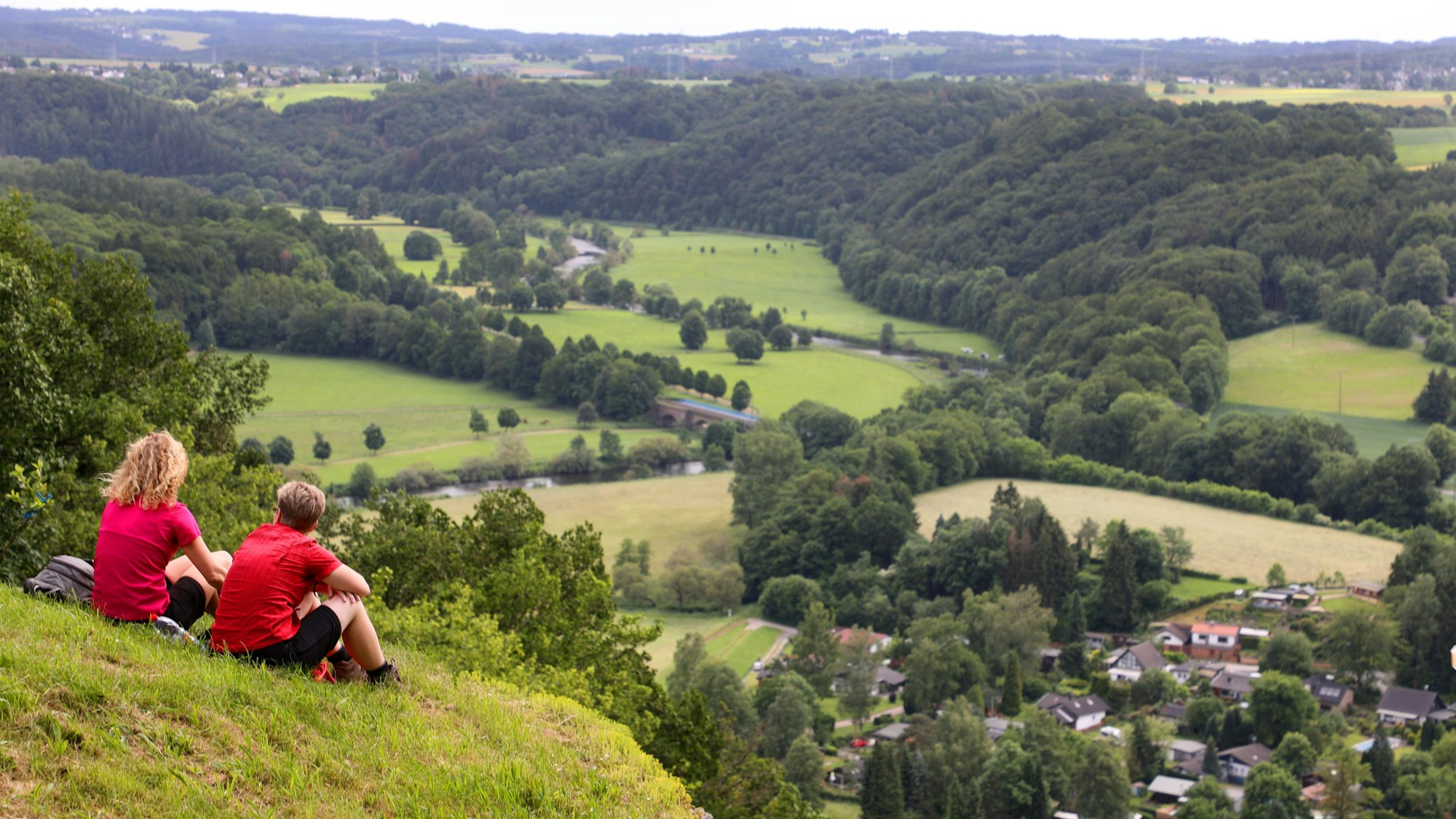 Zwei Frauen sitzen auf der Wiese auf der Stachelhardt und schauen ins Siegtal.