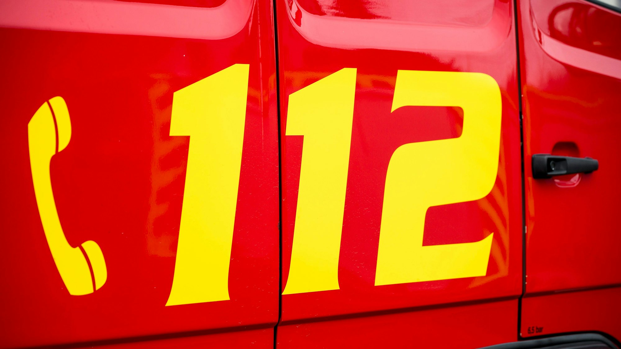 Der Notruf 112 ist auf einem Einsatzwagen der Feuerwehr zu sehen.
