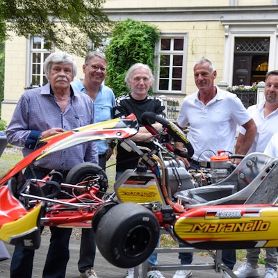 Mehrere Männer stehen hinter einem Kart.