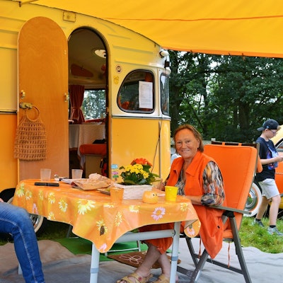 Hildegard und Thomas Hansen sitzen vor ihrem historischen Wohnwagen aus den 70er-Jahren.