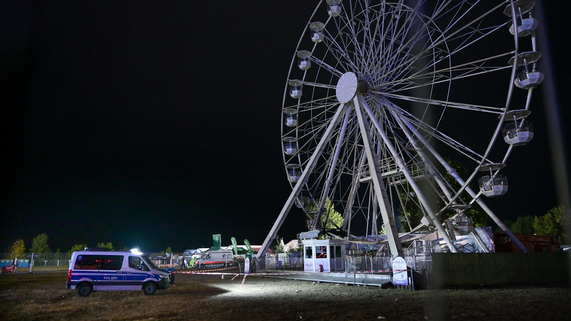 Das Riesenrad wird von der Polizei bewacht beim Highfield-Festival.