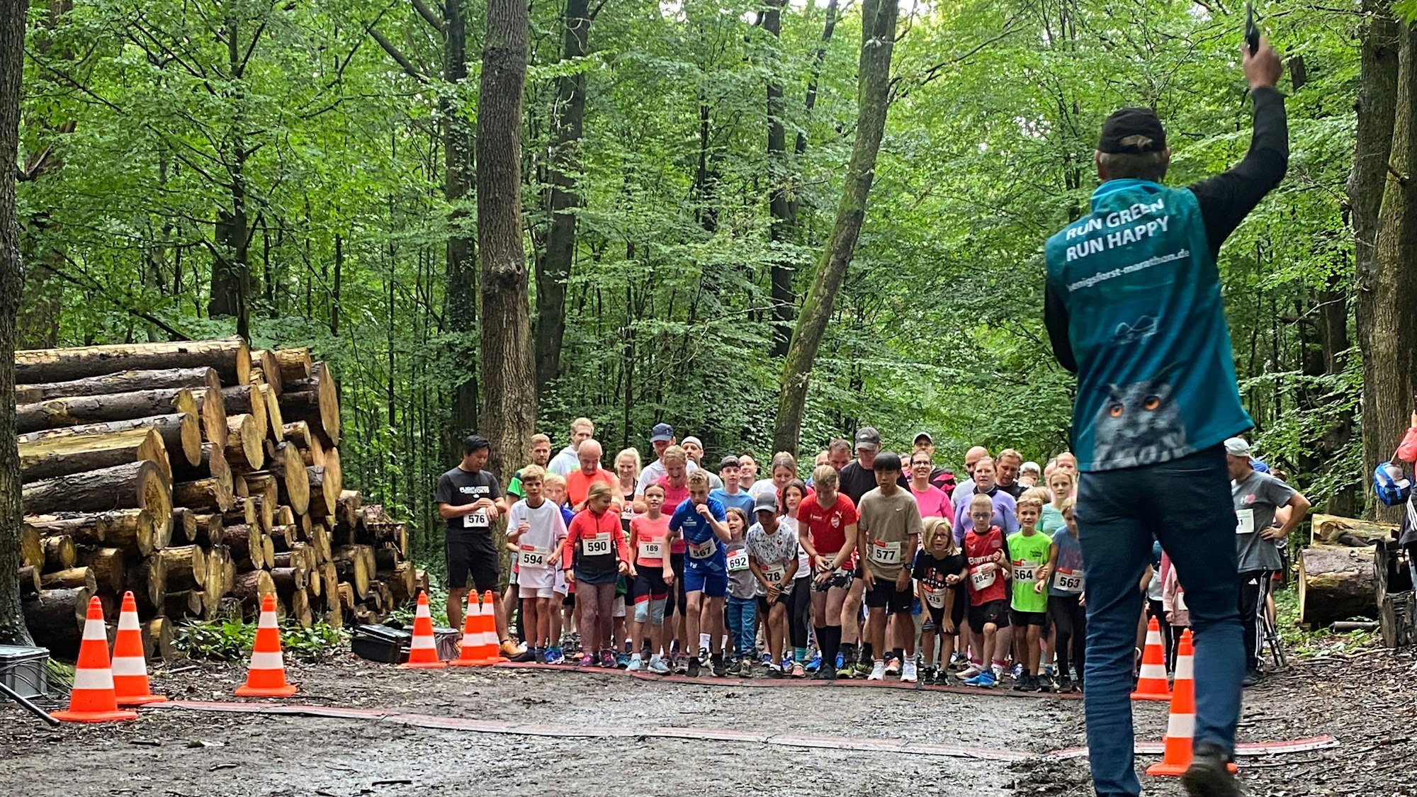 Kinder und Erwachsene stehen im Wald zu einem Langlauf bereit.