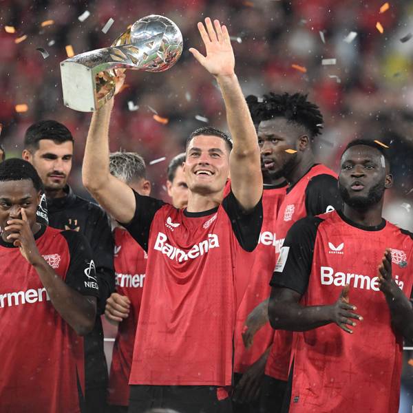 Leverkusens Patrik Schick hält in mitten des jubelnden Teams den Supercup.