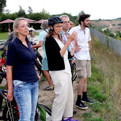 Frauen und Männer schauen auf die Weiten des Tagebaus Hambach.