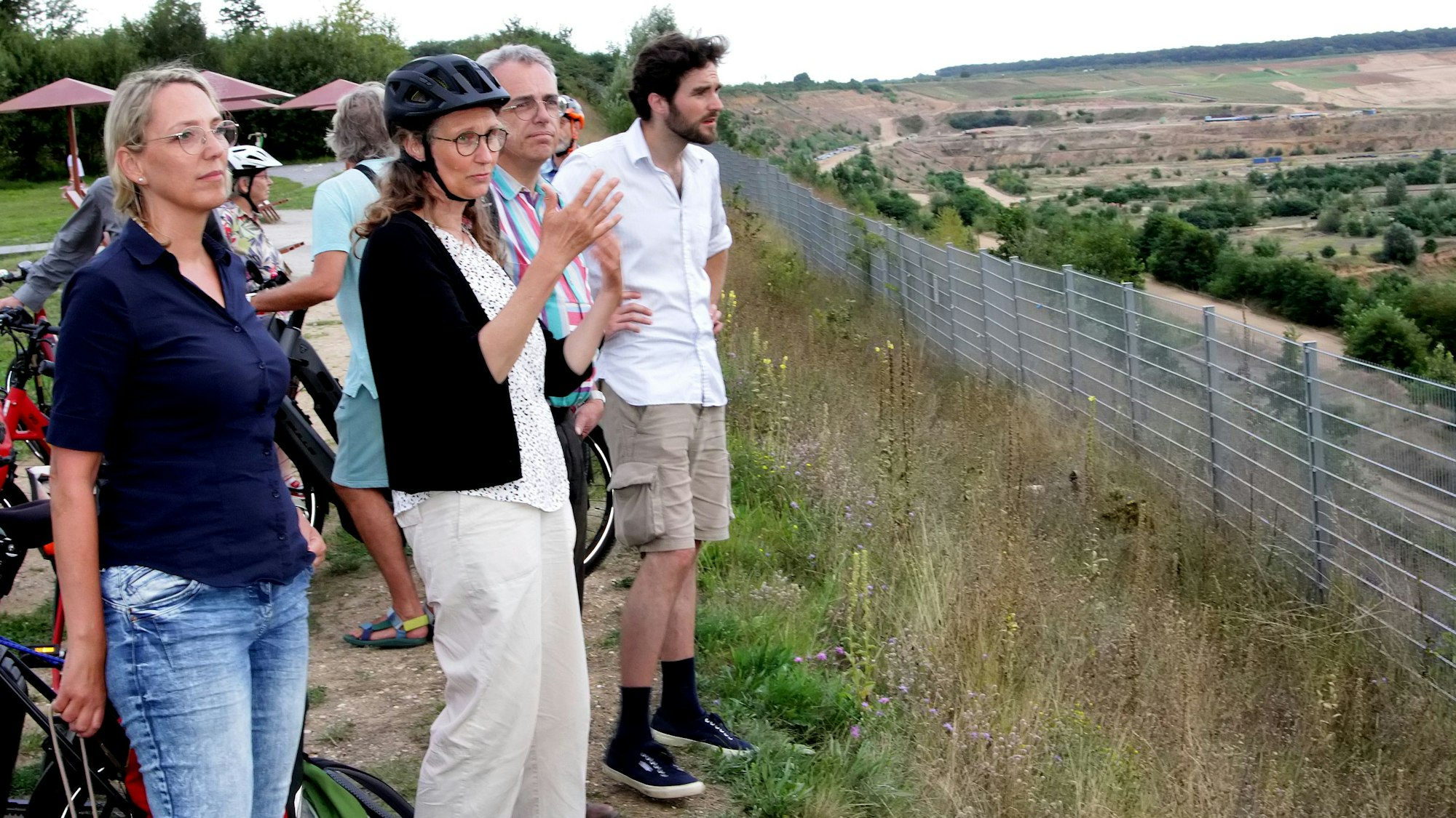 Frauen und Männer schauen auf die Weiten des Tagebaus Hambach.