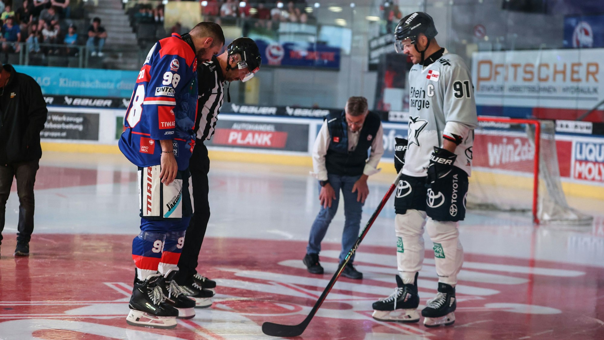 Haie-Kapitän Moritz Müller (r.) begutachtet das Loch im Eis; die Testpartie musste abgebrochen werden.