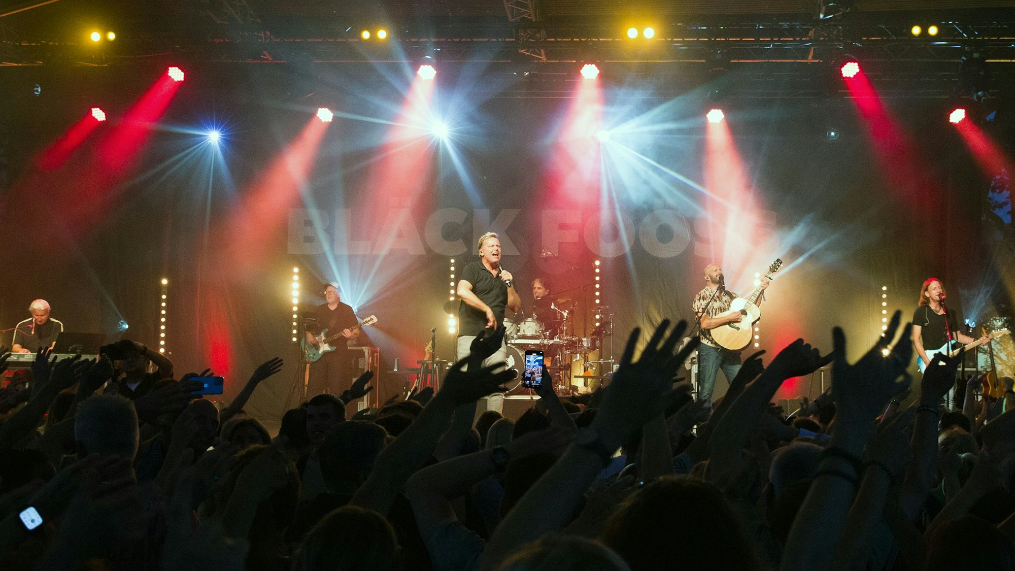 Die Bläck Fööss stehen auf der Bühne am Tanzbrunnen und singen.